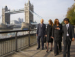 Business men and women walking besides the River Thames