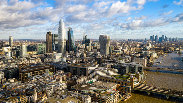 The London skyline featuring iconic buildings with the Canary Wharf complex further in the background