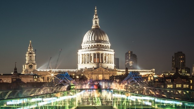 a night view of St Paul's cathedral from an illuminated Millennium Bridge