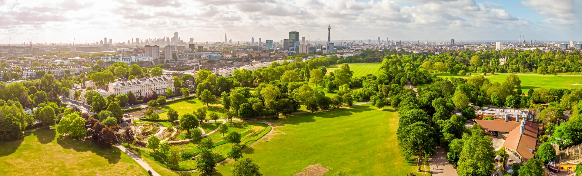 A daytime aerial view of Regent's Park with the skyline of London in the background