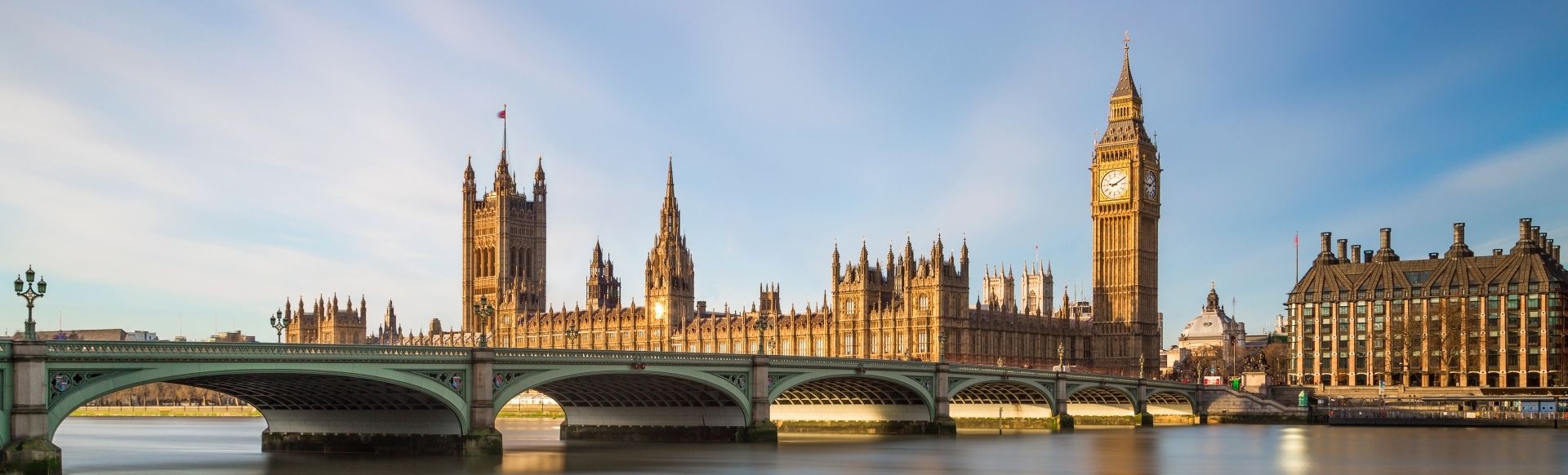 Big Ben, Houses of Parliament and Westminster Bridge in golden sunlight in Westminster.