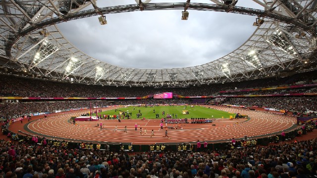 A full audience cheer on athletes as they run to the finish line during a race at the London Stadium 