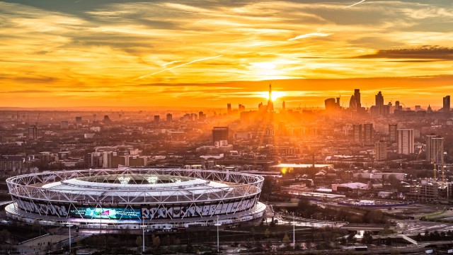 London skyline at sunset with London stadium in the foreground.