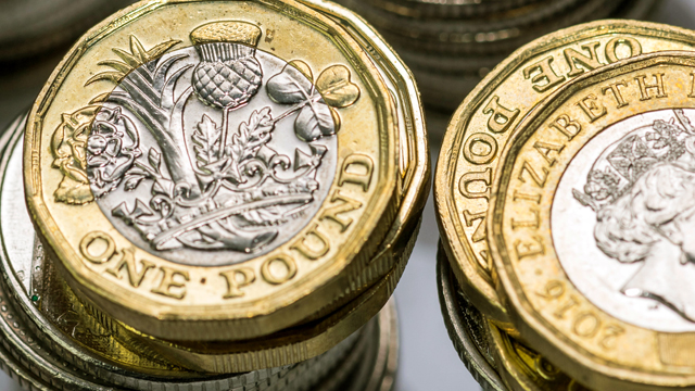 One pound coins stacked on each other.