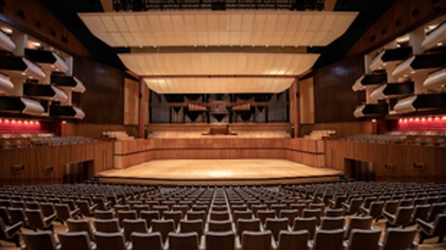 The view from a seat in the auditorium at Southbank Centre with seats and stage in front and balcony seats on either side