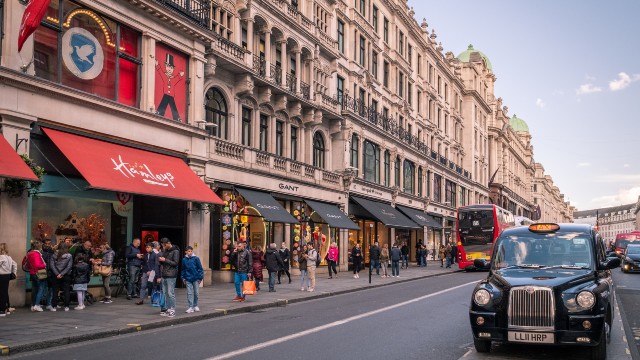 The Hamleys shop front and Regent Street sprawling across with a red bus and black cab driving along.