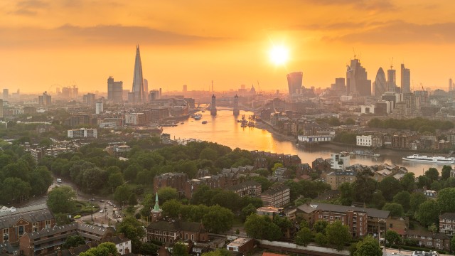 Sunset over the river Thames with the city's skyscrapers including The Shard in the background.