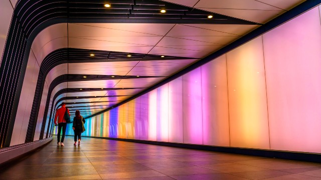 Two people walking though King's Cross tunnel.