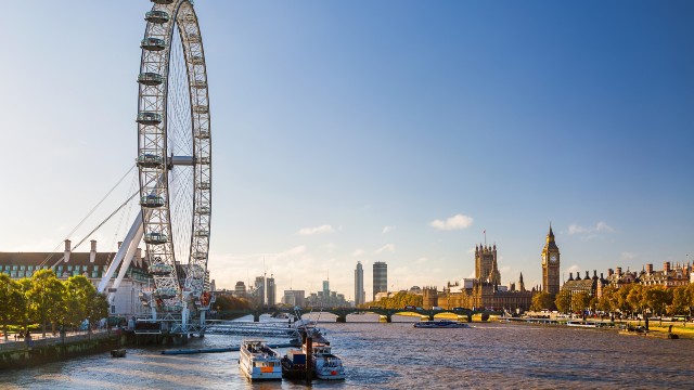 The sun shining over the river Thames, Westminster's Abbey and the London Eye.