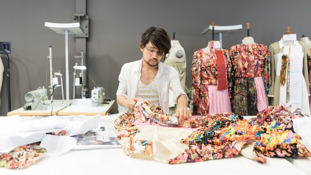 A student is working on creating colourful clothes.