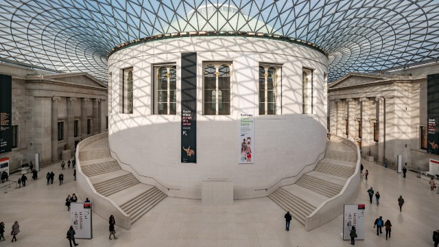 Visitors wander through the glass-roofed atrium of the British Museum