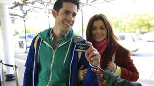 A male and female couple show their London Pass to get into a tourist attraction