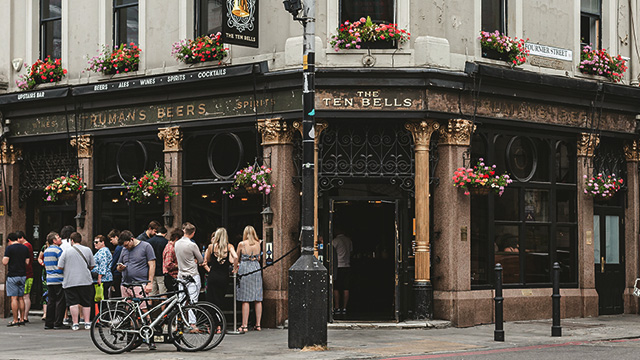 People gather outside the front of The Ten Bells pub to enjoy drinks