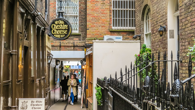 The Ye Olde Cheshire Cheese sign hangs on the side of the historic pub