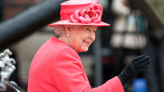 Queen Elizabeth II smiles while waving during an event