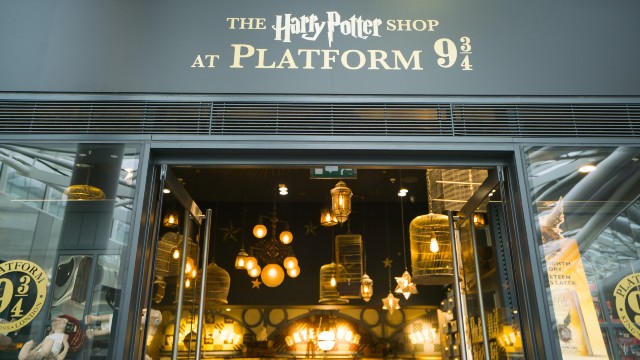 The Harry Potter Shop at Platform 9 and 3/4 storefront with enchanting lamps covering the ceiling inside. 