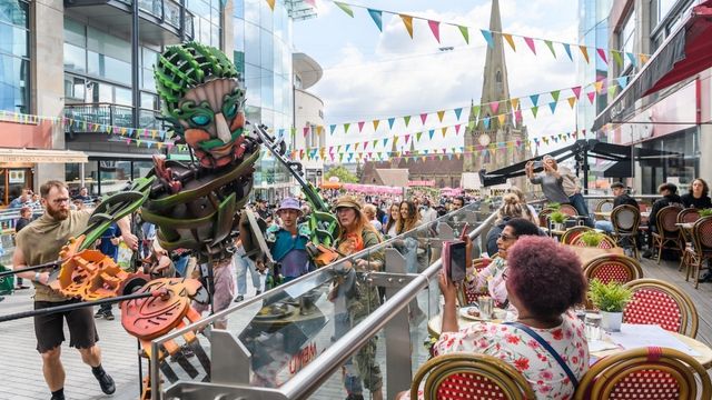 A giant puppet interacts with crowds as people enjoy an immersive display at the Greenwich+Docklands International Festival in London.