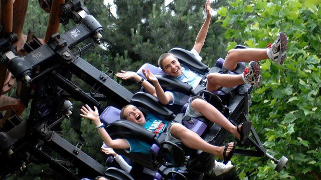 Kids with their hands up in the air enjoying a ride at the Chessington World of Adventures theme park.