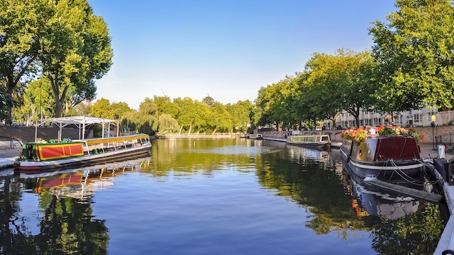 Houseboats on the calm waters of the Canal in Little Venice, London, on a sunny day.