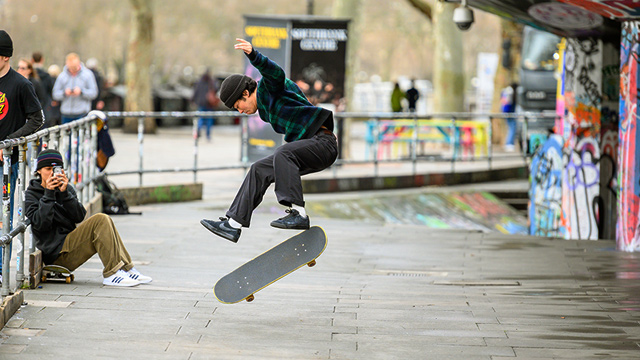 A skateboarder does a trick in the skate park in South Bank London. 