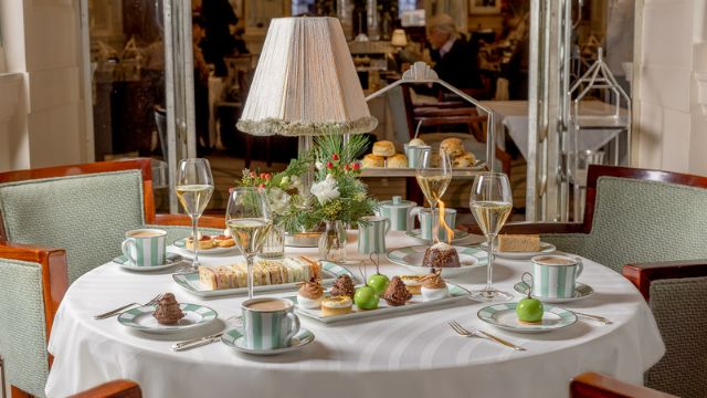 A beautiful table with champagne and sweet and savoury treats at the christmas afternoon tea at claridge's london.