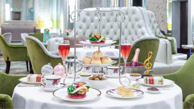 A white table with green chairs at park lane langham with a christmas afternoon tea.