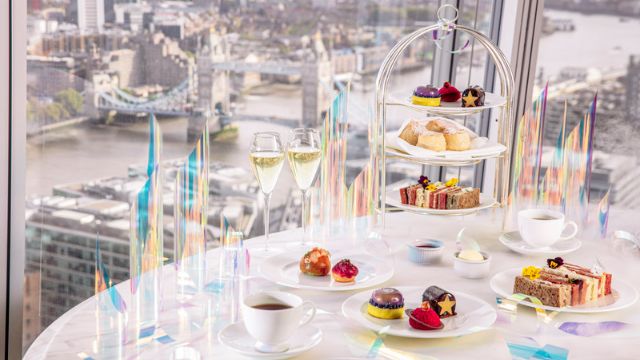 A table covered in sweet and savoury treats at a festive afternoon tea overlooking the London skyline from the shard.