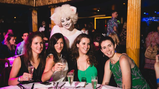 A group of people pose with a cast member of the cats musical at a west end musical themed-brunch in London.