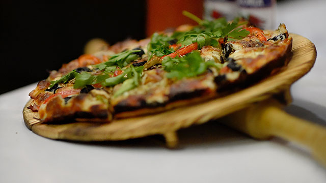 A pizza on a wooden serving board