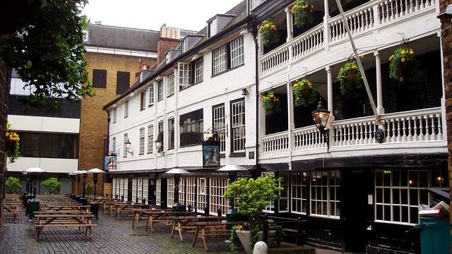 The exterior of The George Inn, with its white galleries and picnic tables in the courtyard.