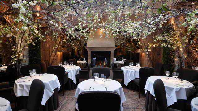 Vue sur l'intérieur du restaurant Clos Maggiore sur Covent Garden avec ses tables coubvertes de nappes blanches.