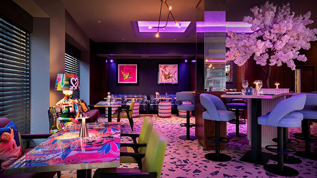 The colourful and eclectic interior of the Eat Drink & Play bar and restaurant at the NYX Hotel in the evening