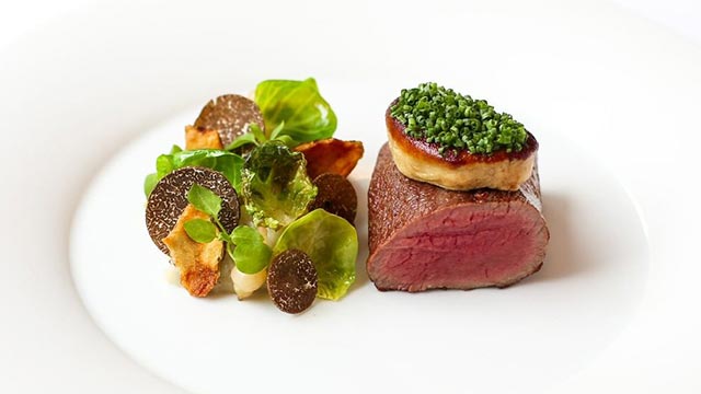 A fillet of venison, cooked pink, sits alongside a salad including black truffle at Pétrus.
