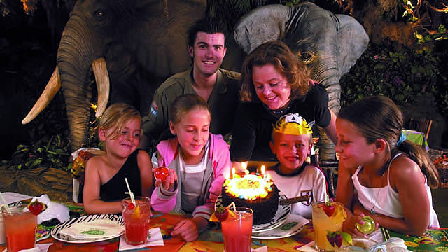 Rainforest Cafe family birthday party with a cake and candles. Image courtesy of Rainforest Cafe.