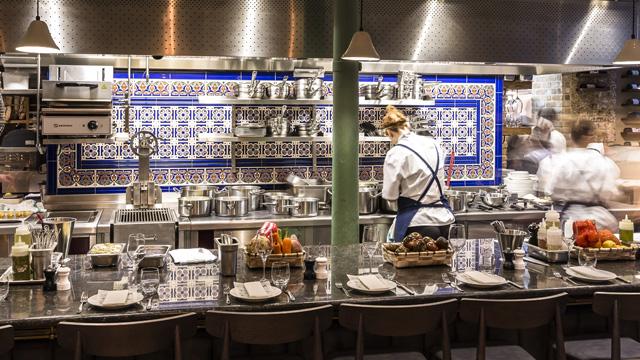 The counter at Sabor in Heddon Street, with servers facing blue and white tiles on the back wall.