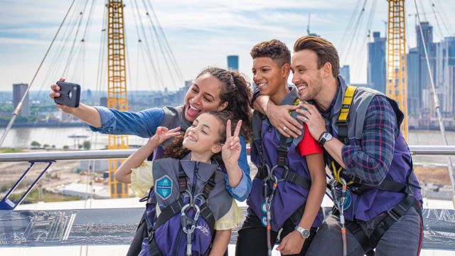 A family take a photo at the london attraction up at the O2 after climbing the O2 stadium. 
