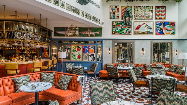 The jazzy interiors of the ivy tower bridge, with bright tiles, paintings on the walls and orange sofas.