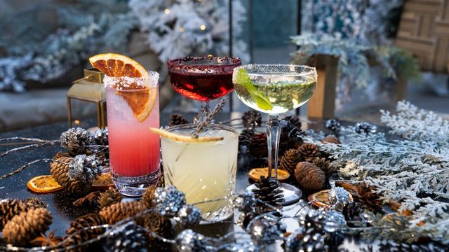 A table of festive cocktails on a winter decorated table. 