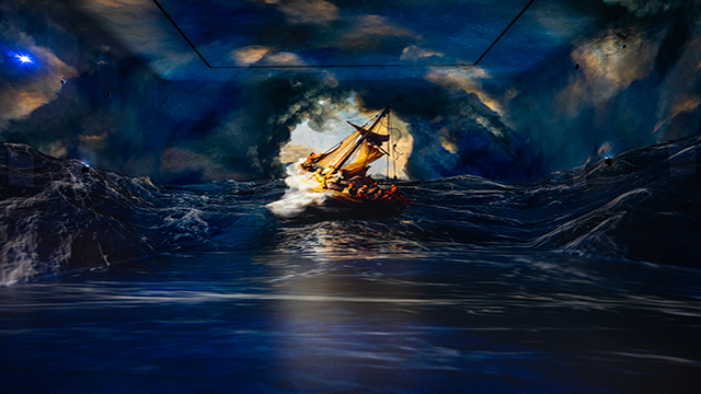 „Christus im Sturm auf dem See Genezareth" von Rembrandt wird auf vier Leinwände projiziert und zeigt ein Schiff, das mit einem Sturm auf See ringt.