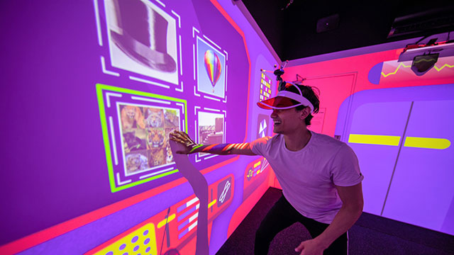 Un homme dans une LightBox multicolore participe à un jeu en immersion sensorielle.