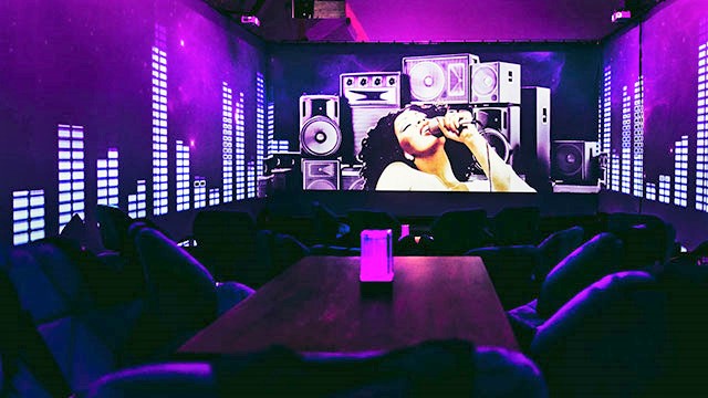 a soul singer projected onto a purple wall in a lounge