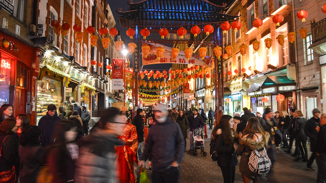 Blurred people walking through London Chinatown at night.