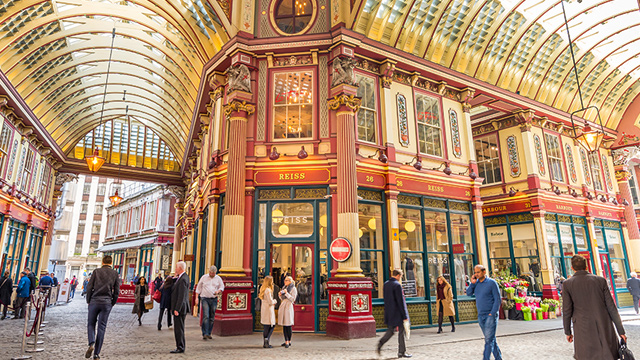 People walking past the shops of Leadenhall Market in the City, London.