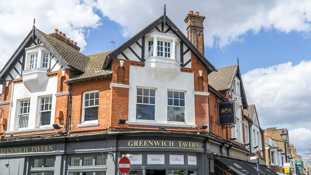 The front of a large, redbrick pub in Greenwich on a sunny day.