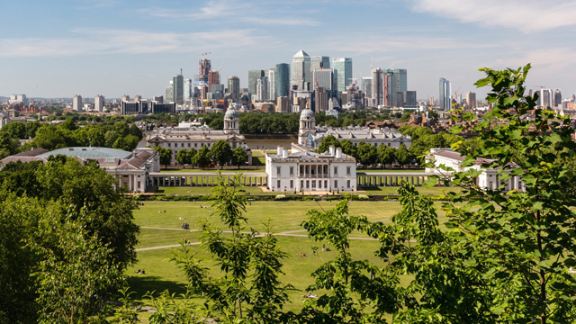 Greenwich Park on a sunny day with views of iconic buildings in the London skyline