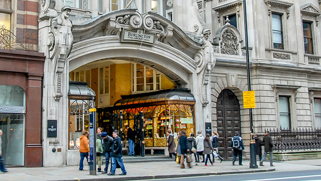 People walking past the Burlington Arcade entrance on Piccadilly in central London.