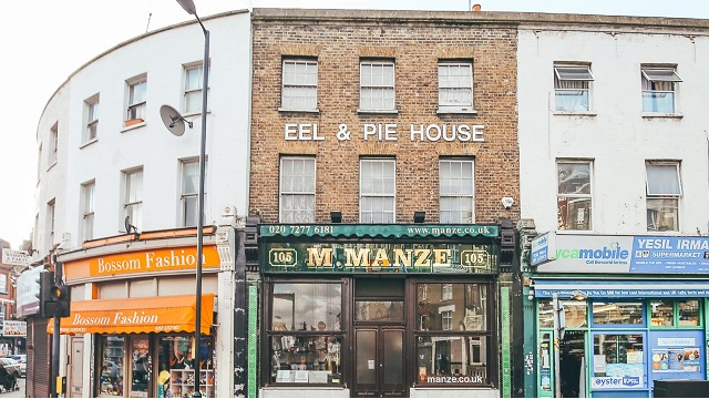 Exterior of M Manze shop on Peckham High Street, with eel & pie house written on brick wall overhead