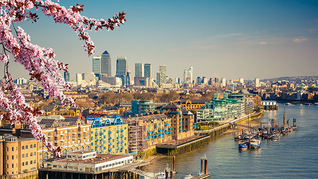 london and the river thames in  the spring with canary wharf in the background on a sunny day.