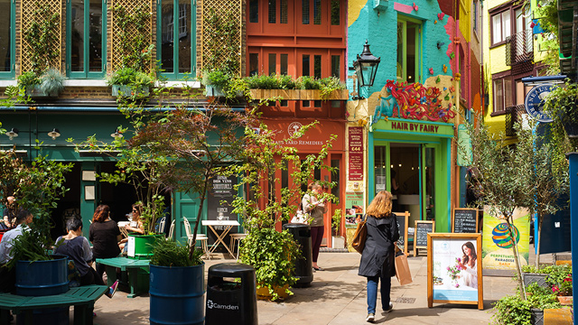 Colourful buildings and a woman wandering about in Neal's Yard, central London.