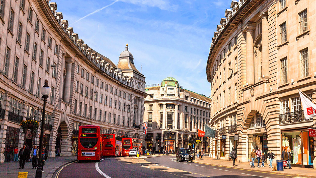 Die Regent Street im Londoner West End an einem sonnigen Tag mit roten Londoner Bussen, die vorbeifahren. 